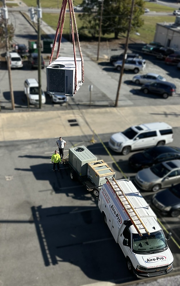 CraneLiftingUnit crane lifting commercial heating and air unit onto a rooftop